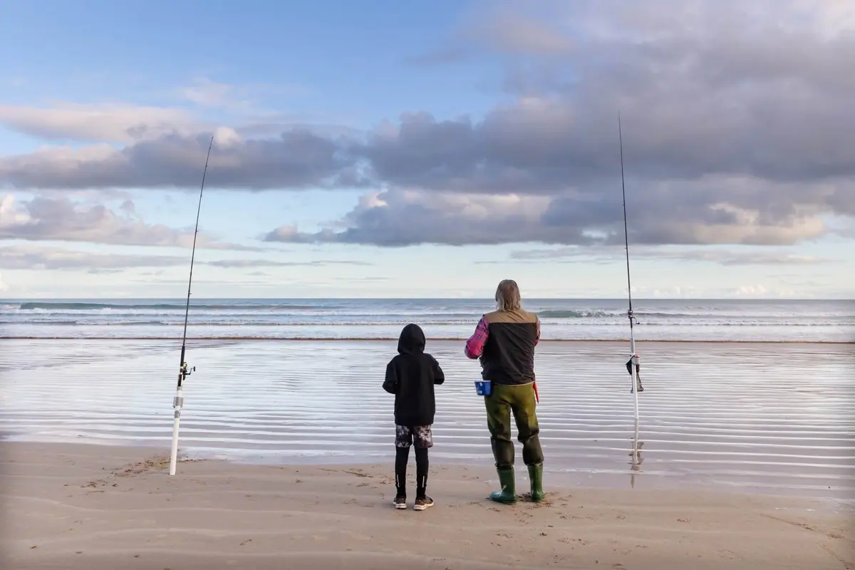 A family fishing from the beach at Sandy Point